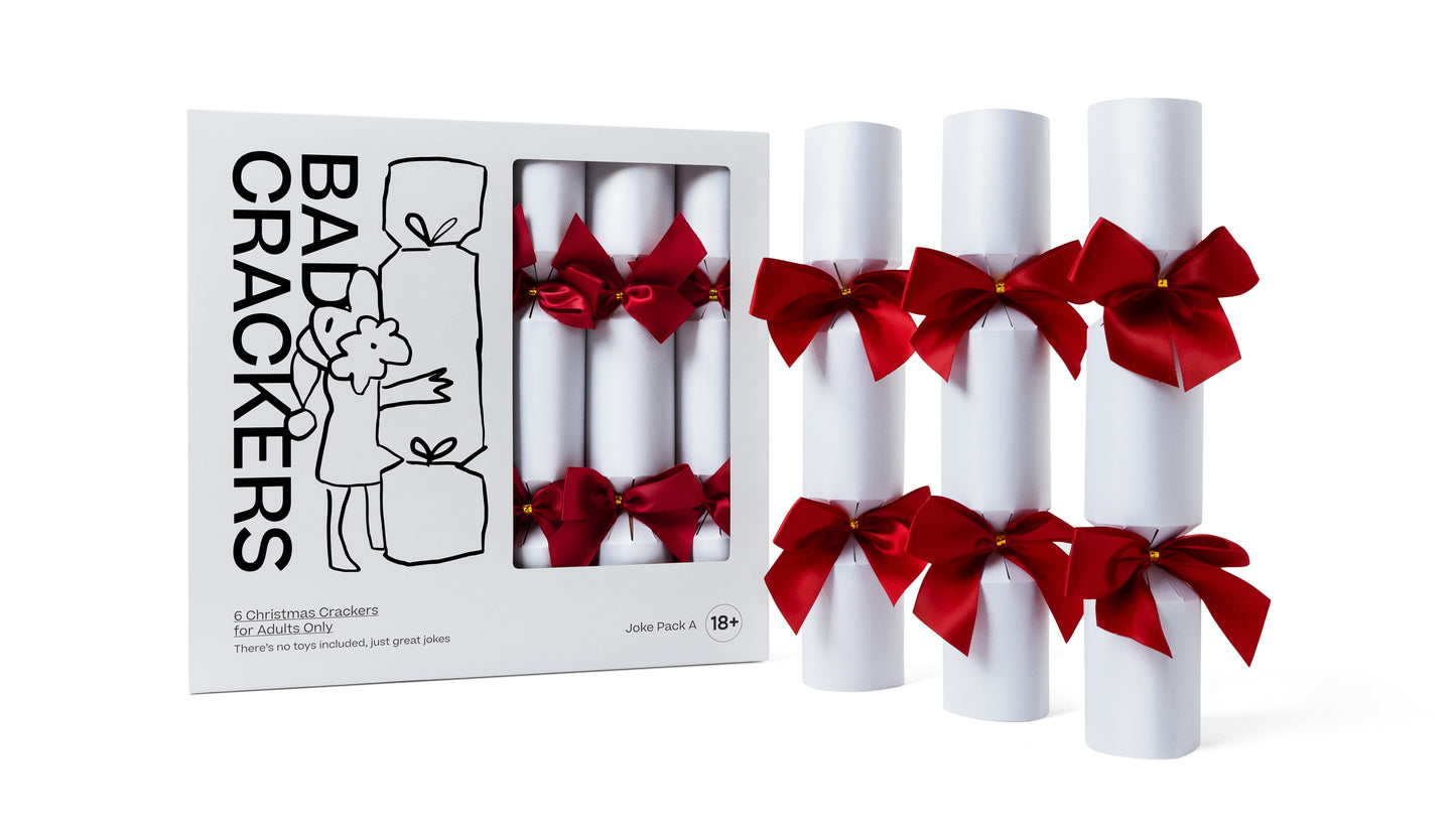 Bad Crackers Pack A, with 3 Christmas crackers outside the box. The Crackers are white with red bows